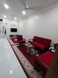 a living room with a red couch and a rug at Akiera Homestay #MELAYU ONLY in Pelabuhan Kelang