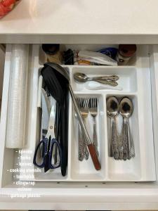 a drawer filled with utensils in a cabinet at Julia HavenStay, Sepang KLIA in Sepang