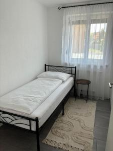 a bed sitting in a room with a window at Gemütliche Wohnung in Puch in Puch bei Hallein
