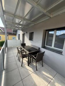 a patio with a table and chairs and a window at Gemütliche Wohnung in Puch in Puch bei Hallein
