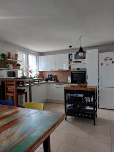 a kitchen with white cabinets and a wooden table at Apartment Mamut in Premantura