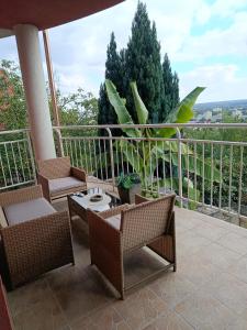 a patio with chairs and a table and a plant at Panoráma apartman in Pécs