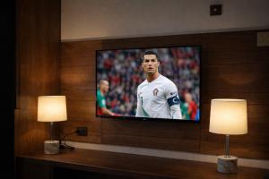 a flat screen tv on a wall with two lamps at Hotel Star Islamabad in Islamabad