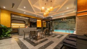 a dining room with a table and chairs and a swimming pool at Teymur Continental Hotel in Gaziantep