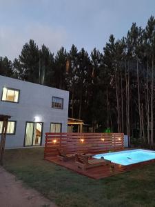 a house with a swimming pool in the yard at Cabañas del Sol in Punta Del Diablo +28 photos