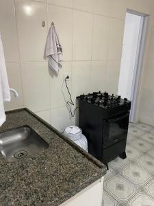a kitchen with a sink and a stove in it at Casa no Roteiro do Vinho - Casa 02 in São Roque