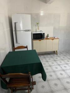 a kitchen with a green table and a refrigerator at Casa no Roteiro do Vinho - Casa 02 in São Roque +3 photos