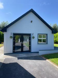 a white building with a large glass door at Greenway Cottage in Baltonʼs Cross Roads