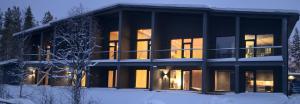 a large building with lights on in the snow at Metsolinna in Kittilä