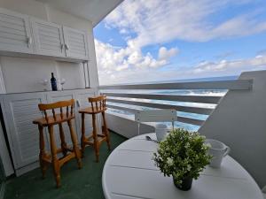 a balcony with a table and two chairs and the ocean at Sunset living area in Puerto de la Madera