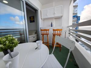 a balcony with a white table and chairs and the ocean at Sunset living area in Puerto de la Madera