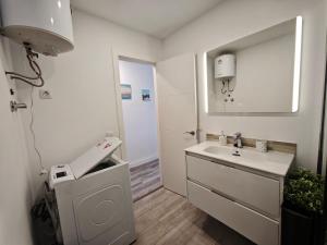a white bathroom with a sink and a mirror at Sunset living area in Puerto de la Madera +22 photos
