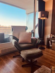 a chair in a living room with a large window at Premium Apartment-OstseePur-inklusive Parkplatz-Wlan-Strand-und Citynähe in Timmendorfer Strand +44 photos