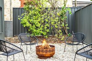 a fire pit in a yard with chairs and a fence at The Wharf House Goolwa in Goolwa