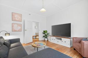 a living room with a couch and a flat screen tv at The Wharf House Goolwa in Goolwa