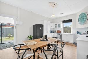 a kitchen and dining room with a wooden table and chairs at The Wharf House Goolwa in Goolwa