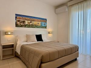 a bedroom with a large bed and a large window at Hotel Jonio in Noto Marina +51 photos