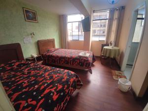 a hotel room with two beds and a window at Hotel Savoy in La Paz
