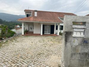 a small white house with a tile roof at Quinta do Lameiro Maceira in Seia