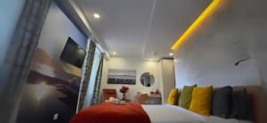 a bedroom with a bed with yellow and black pillows at Le Petit Trianon et le Charme des Suites in Nice