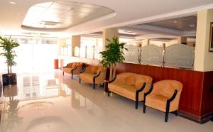 a waiting room with chairs and a long table at Jubail Inn in Al Jubail