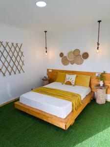a bedroom with a wooden bed with a yellow blanket on it at Quinta Refúgio in Ribeirão Chiqueiro +19 photos