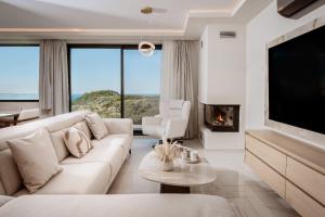 a living room with a white couch and a tv at Sunset Dream Luxury Villa in Keri