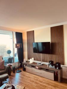 a living room with a flat screen tv on a wall at Premium Apartment-OstseePur-inklusive Parkplatz-Wlan-Strand-und Citynähe in Timmendorfer Strand