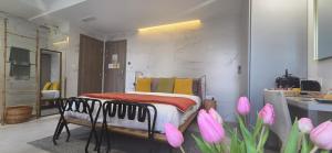 a bedroom with a bed and pink flowers in a room at Le Petit Trianon et le Charme des Suites in Nice