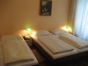 two twin beds in a room with two lamps at Pension Schottentor in Vienna