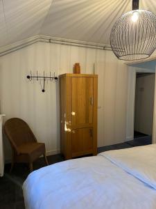a bedroom with a bed and a cabinet and a chandelier at De Schuure 't Voorde in Winterswijk in Winterswijk