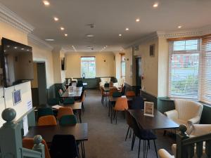ein Wartezimmer mit Tischen und Stühlen in einem Restaurant in der Unterkunft Captain Howey Hotel in New Romney