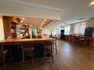 eine Bar in einem Restaurant mit Holzböden und Stühlen in der Unterkunft Captain Howey Hotel in New Romney