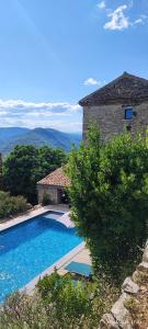 a swimming pool in front of a stone house at MAS Estrela Chambre Lo Nis in Bessèges