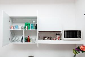 a white kitchen with a microwave and a counter at Departamento Palmita in La Paz