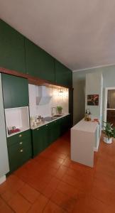 a kitchen with green cabinets and a white counter at Il Sonetto Boutique Apartment - private garage in Mantova
