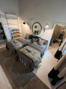 a bedroom with two beds and a mirror on the wall at Calitzdorp Self-Catering Guesthouse - Oudehuis in Calitzdorp