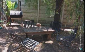 a wooden table and chairs next to a tree at Casa Las Marías in General Belgrano +6 photos
