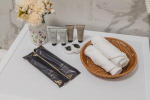 a white table with a basket of towels and a vase at Five Business-class rooms in R-house near Mega Center Almaty in Almaty +169 photos