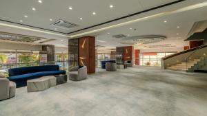 a lobby with a blue couch and a staircase at Teymur Continental Hotel in Gaziantep +55 photos