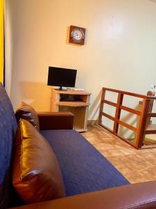 a living room with a couch and a television at Huizenmarkt Caboverde in Mindelo
