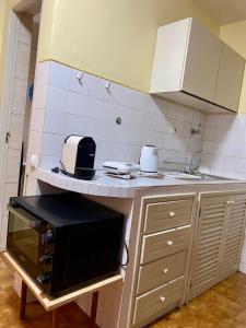 a kitchen with a counter with a microwave on it at Huizenmarkt Caboverde in Mindelo