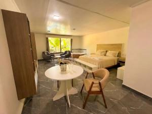 ein Hotelzimmer mit Bett, Tisch und Stühlen in der Unterkunft Hotel Cabañas Complejo Ysyry Misiones in Eldorado