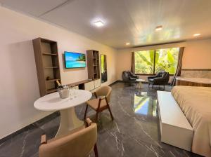 ein Hotelzimmer mit Bett, Tisch und Stühlen in der Unterkunft Hotel Cabañas Complejo Ysyry Misiones in Eldorado
