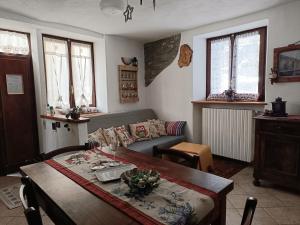 a living room with a table and a couch at Sauze d'Oulx ciabot la garitüla with garden - wifi- close to the chairlift in Sauze dʼOulx