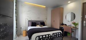 a bedroom with a bed and a desk and a mirror at Le Petit Trianon et le Charme des Suites in Nice