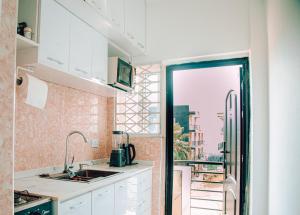a kitchen with white cabinets and a large window at Cosy Apartment with Pool in Kwabenyan +44 photos
