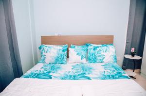 a bed with blue and white sheets and pillows at Cosy Apartment with Pool in Kwabenyan