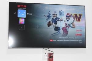 a tv with a football game on the screen at Sunlit Retreat Private Flatlet with Solar Power Pool Fast WiFi & Secure Parking in Roodepoort