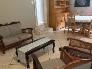 a living room with a couch and chairs and a table at Hekpoort Rorymi Guest farm in Hekpoort